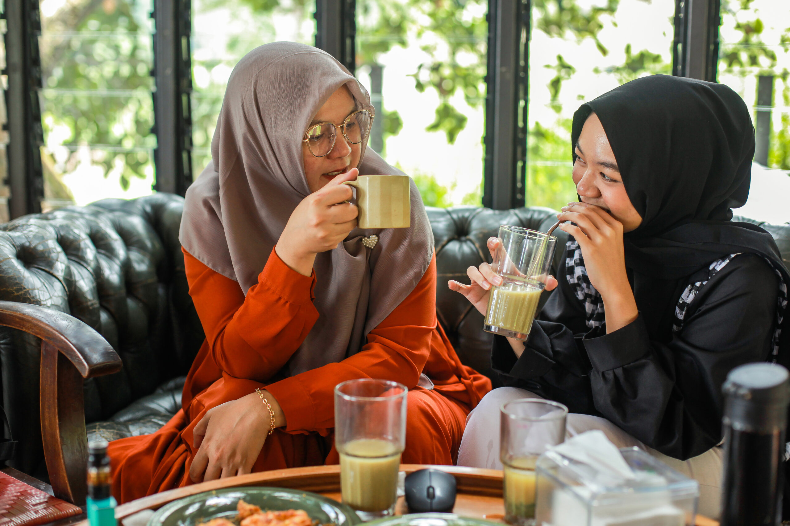 Women drinking coffee and talking at cafe