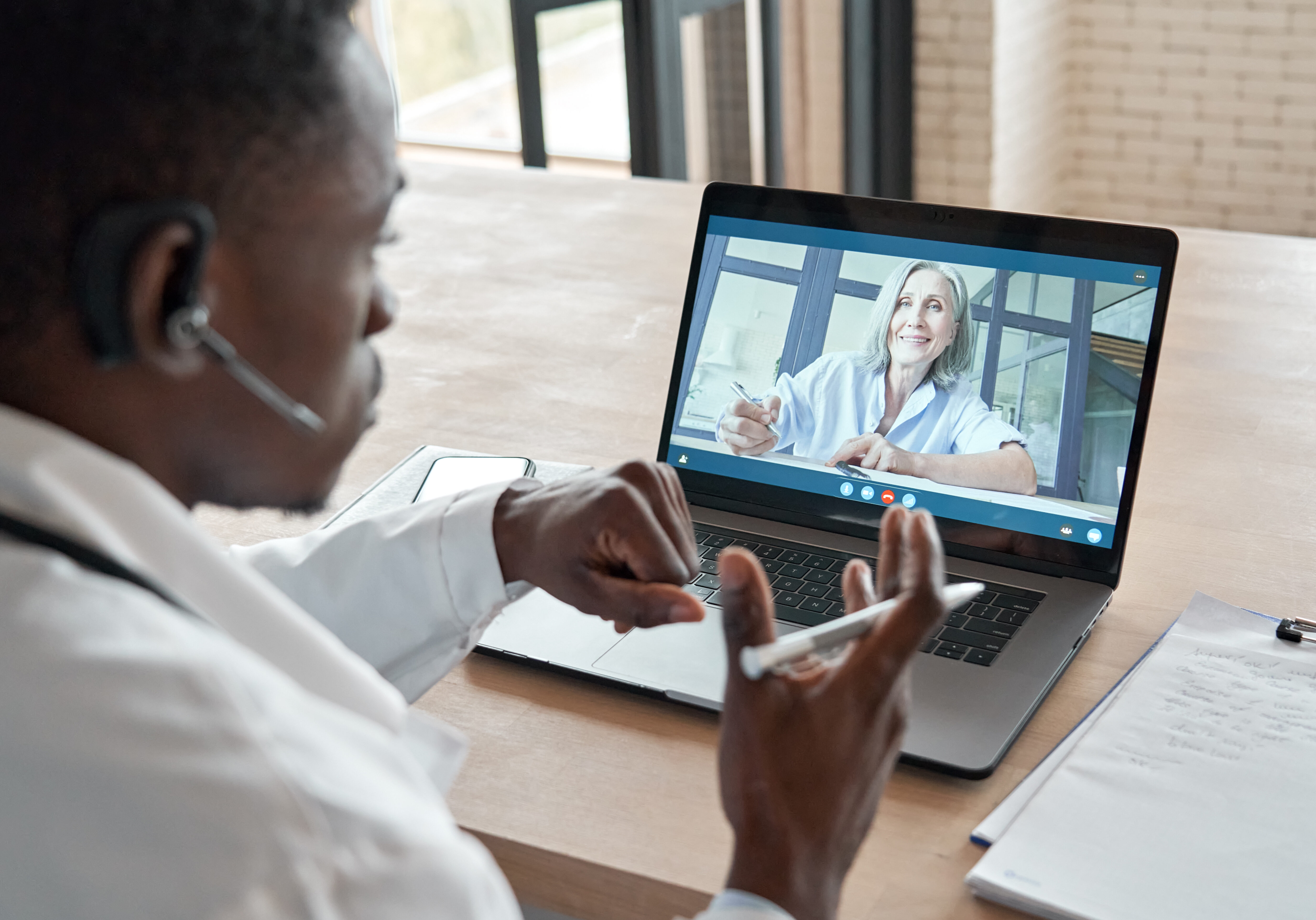 Un médecin donne une consultation par vidéoconférence à une patiente aînée.